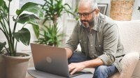 Man doet thuis zijn administratie op laptop