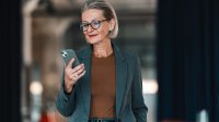 Knappe oudere vrouw met mobiele telefoon