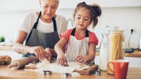 Meisje helpt oma in de keuken