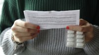 Vrouw leest bijsluiter van medicatie