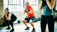 Man en vrouw doen squats met kettlebel en trainen om sterker te worden