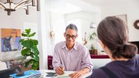 Man en vrouw zijn thuis bezig met papierwerk aan bureau