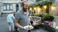 Hippie met man-bun lacht op een vegan barbecue