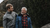 Vader en zoon lopen arm in arm door het bos