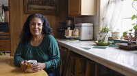 Vrouw met donker haar zit aan de keukentafel