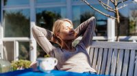 Vrouw geniet van de eerste zonnestralen in de lente