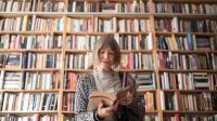 Vrouw in een bibliotheek vol boeken