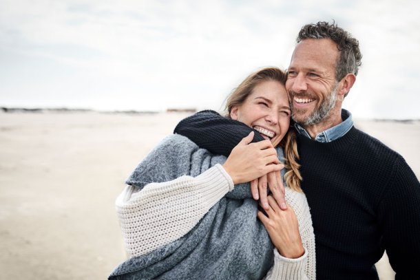 Vrolijk koppel op het strand met wat kouder weer