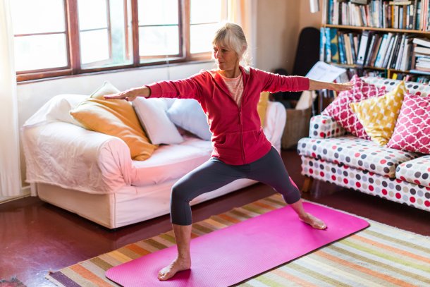 Oudere dame doet aan yoga in kleurrijke yoga kamer