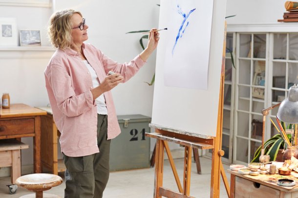 Vrouw schildert kunstwerk op wit doek