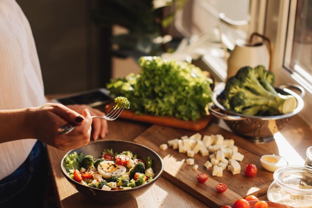 Vrouw in de keuken maakt gezonde maaltijd