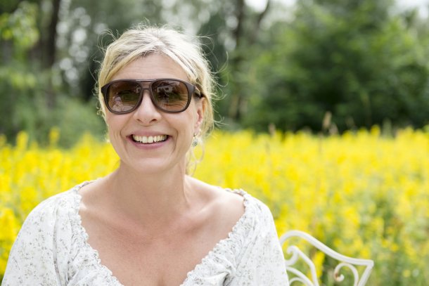 Vrouw met hooikoorts in veld vol bloemen