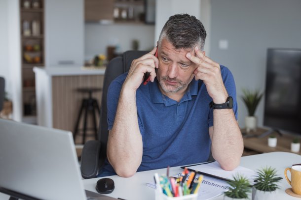 Oudere man bezig met moeilijk telefoongesprek