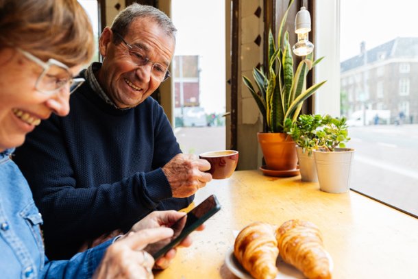 Senior koppel in cafe met smartphone