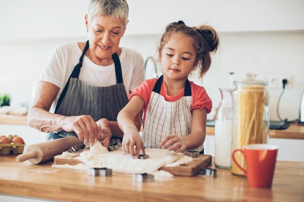 Meisje helpt oma in de keuken