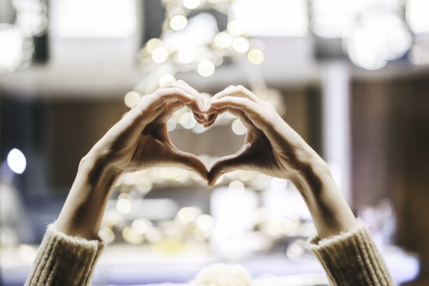 Vrouw maakt met haar handen een hartvorm