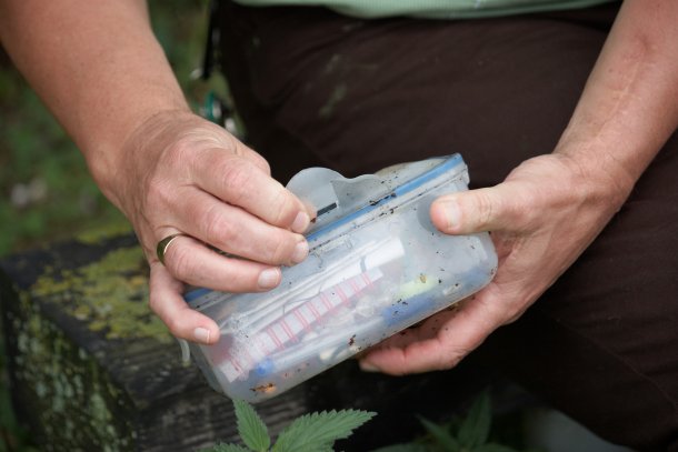 Geocache gevonden in plastic gewikkeld, man heeft in zijn handen