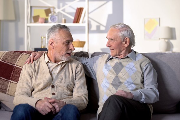 Oudere broers zijn met elkaar in gesprek op een bank in de woonkamer